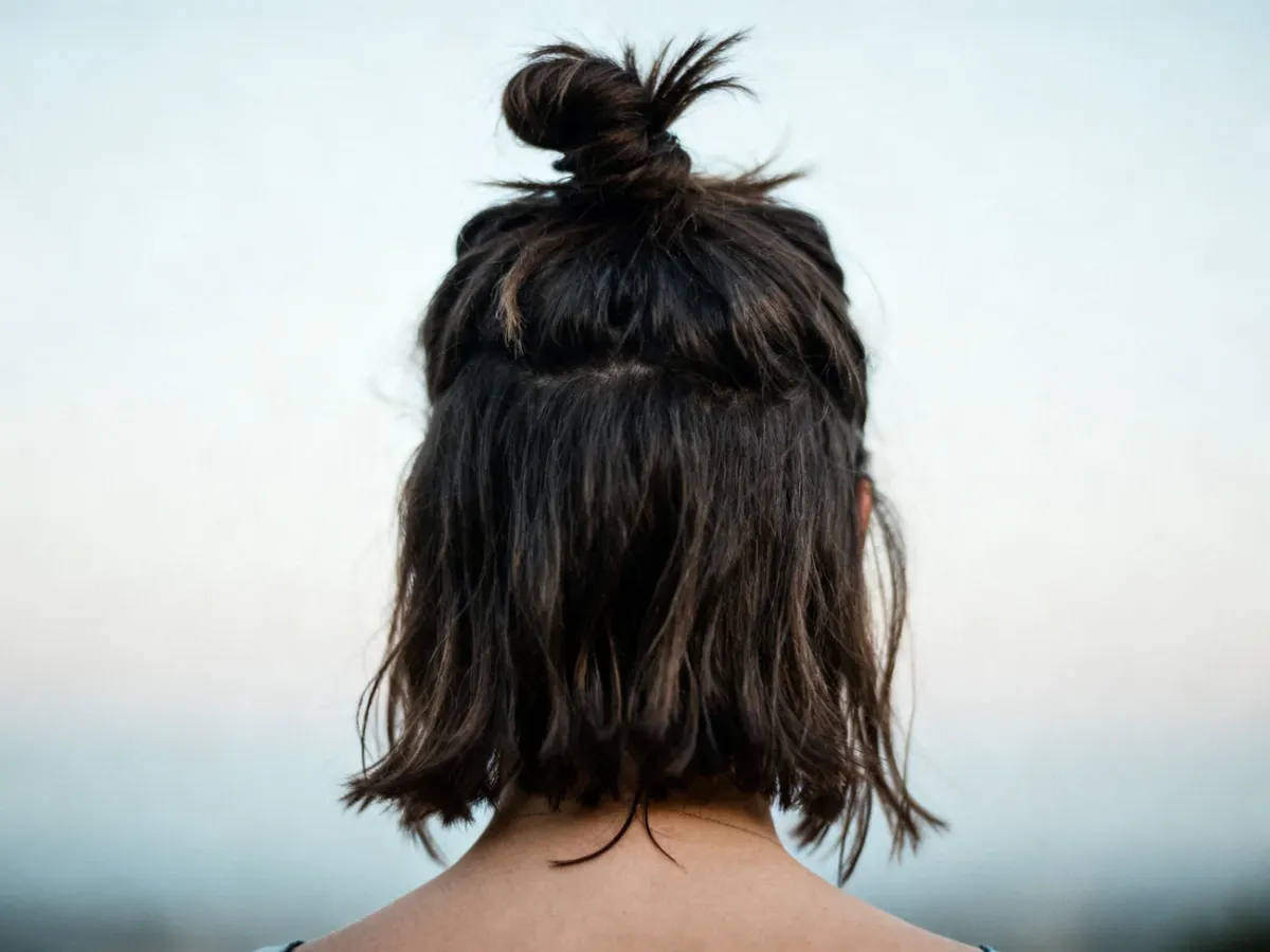 Mały messy bun na włosach do ramion z krótkimi, luźnymi końcówkami